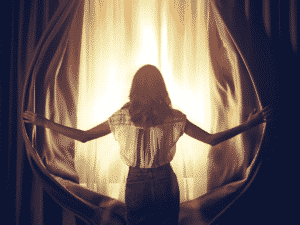 woman opening curtains. What to do when you feel stuck in life.