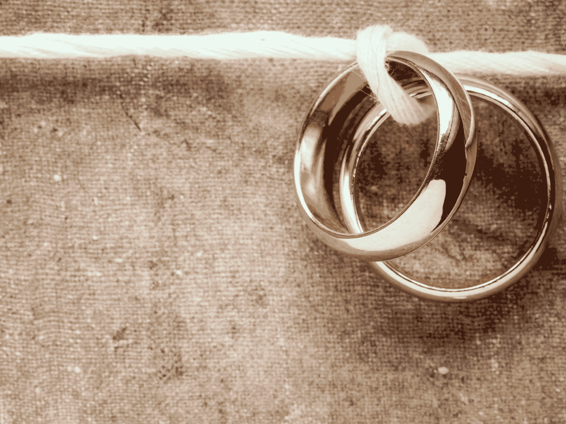 wedding rings tied together representing premarital counseling conversations for commitment