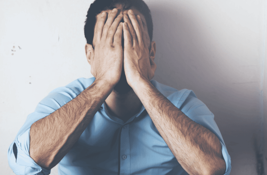 man sitting on floor with face in hands representing healing toxic shame