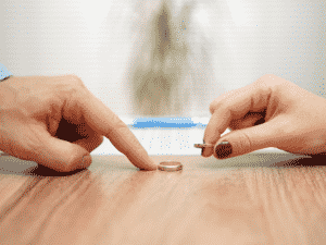 Weddings rings taken off the hands and on the table representing Amicable divorce.
