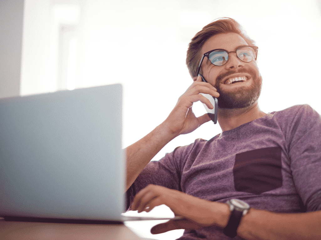 Man on laptop and talking on a cell phone representing How to Improve Emotional Intelligence