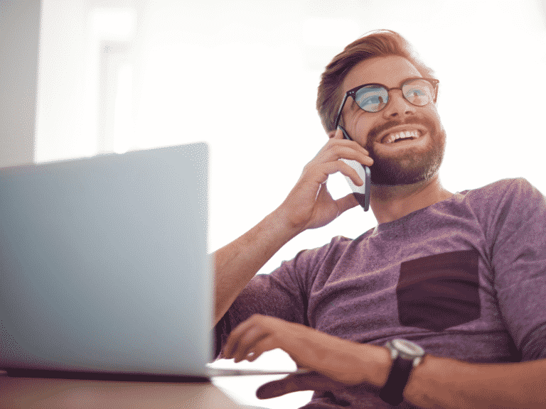 Man on laptop and talking on a cell phone representing How to Improve Emotional Intelligence