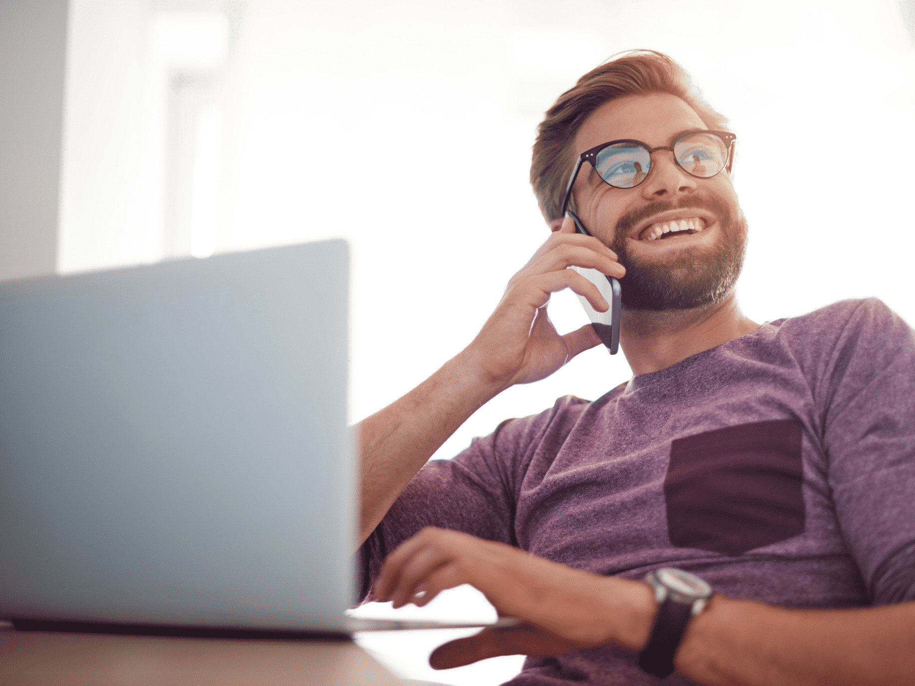 Man on laptop and talking on a cell phone representing How to Improve Emotional Intelligence