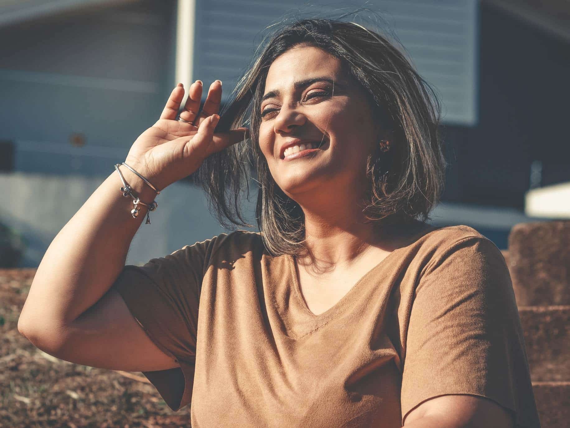 Woman leaning back, looking happy representing Radical Acceptance