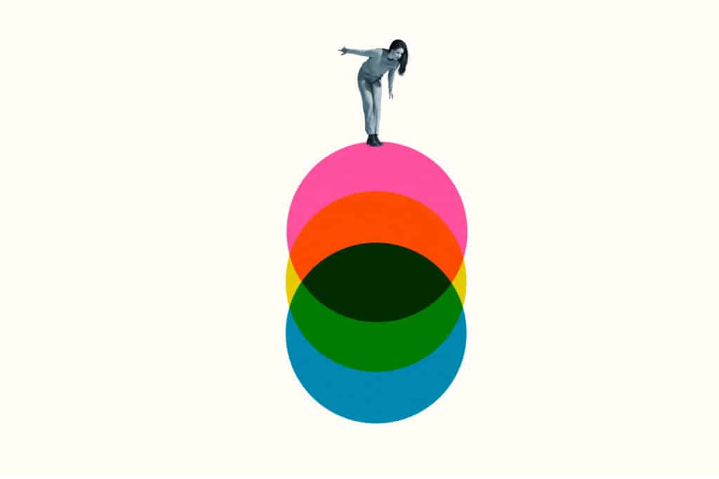 Woman balancing on colorful circles, representing differences of life coach vs therapist