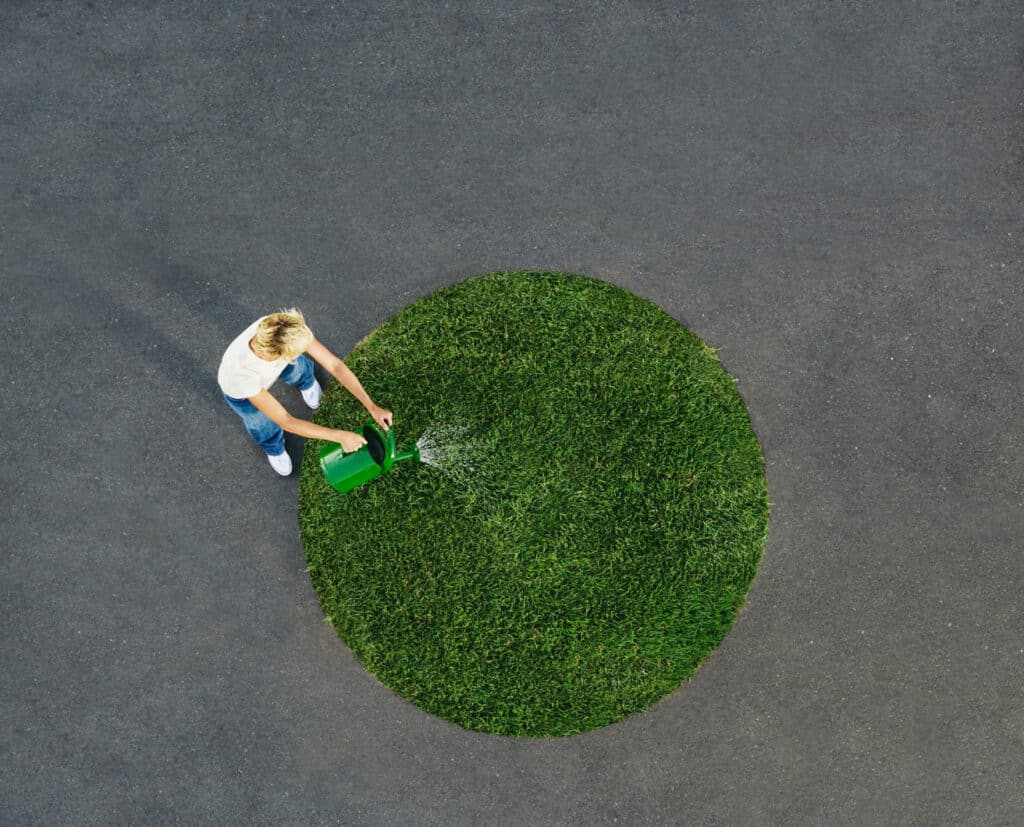 Woman watering grass, wondering, “How much does therapy cost?”