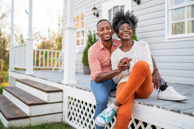 Happy couple on front porch, representing premarital counseling