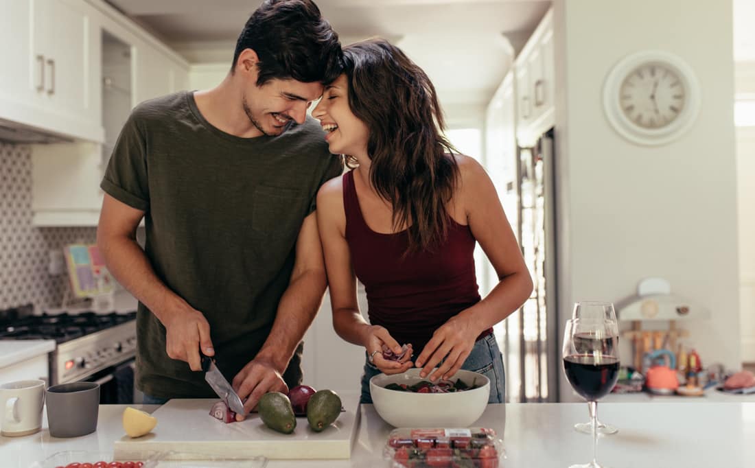 Happy couple baking in kitchen, representing premarital counseling