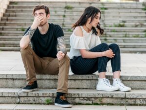 Couples sitting on the steps, facing away from each other. Unhealthy Relationships