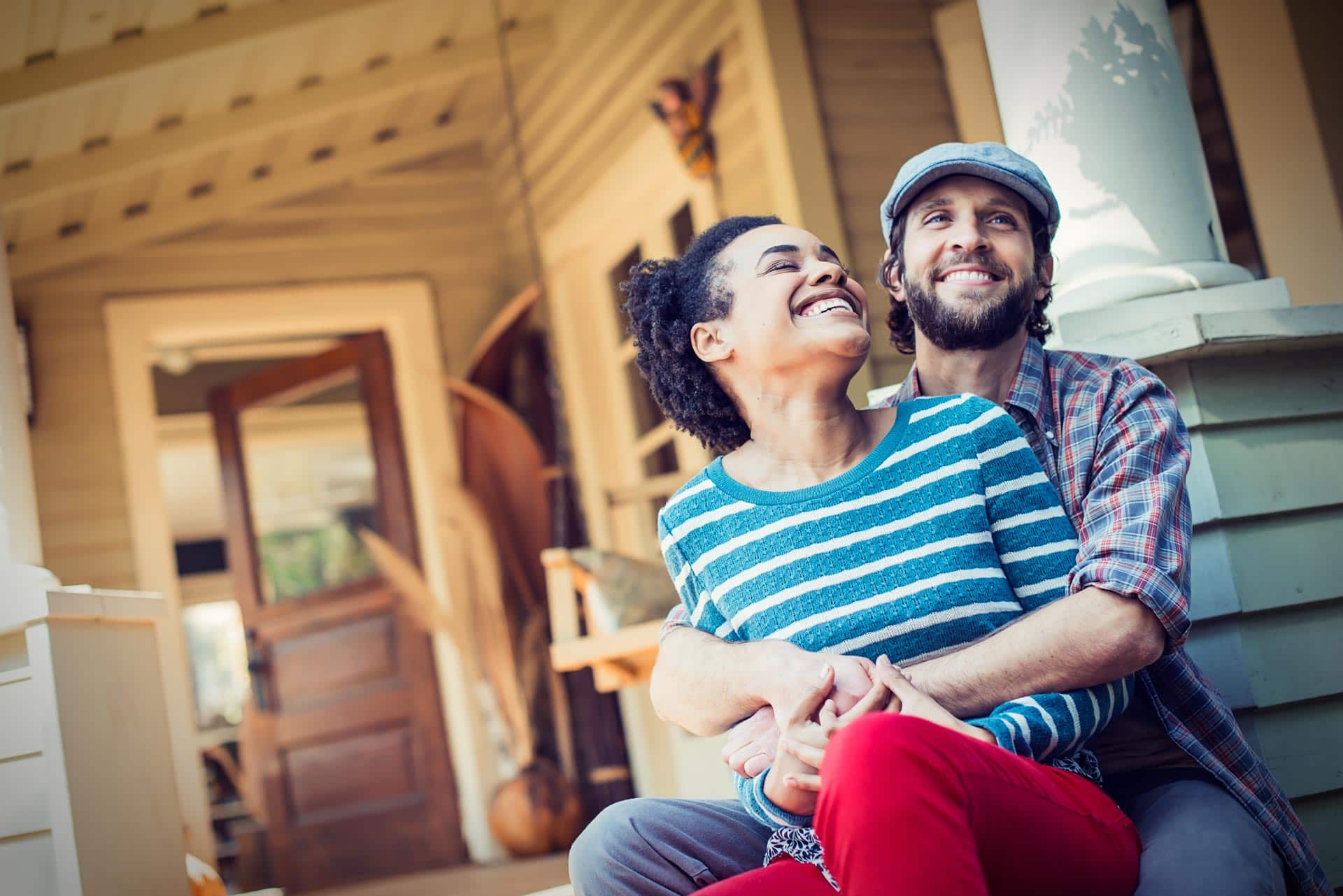 Happy couple sitting on porch, representing dating coaching.