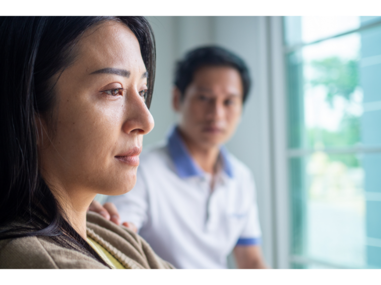 A man reaches toward a woman while she stares off into the distance representing how to recover from a horrible fight