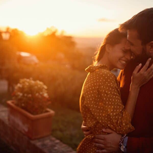 A couple rekindling the romance in their relationship, hugging at sunset.