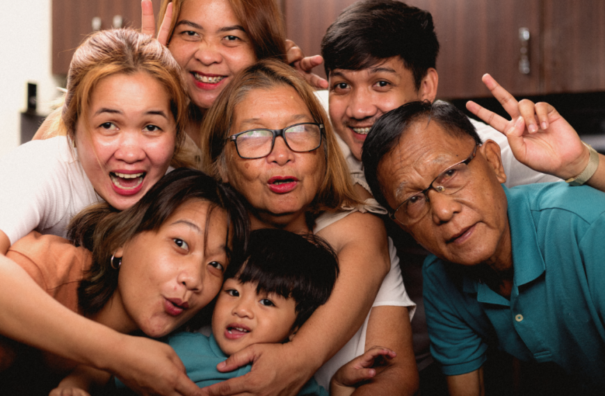 A big extended family smiles for the camera representing setting boundaries with parents