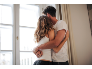 A couple embraces while looking out the window representing what to do when you don't want to be touched