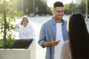 A woman watches as a couple flirts representing how to deal with your ex being with someone else