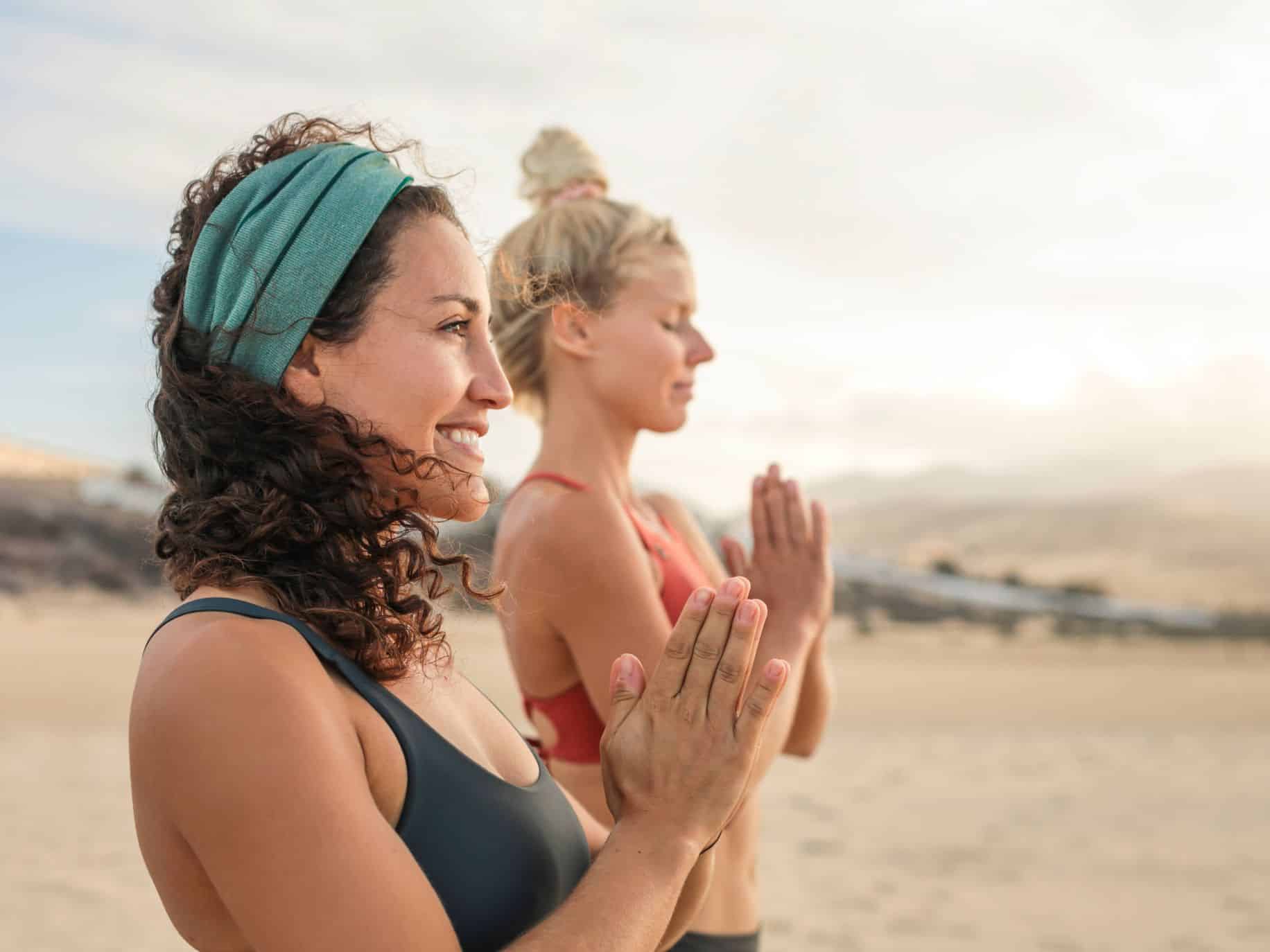 Two women practicing yoga, keeping a commitment to yourself