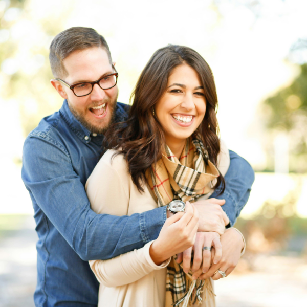 A happy looking couple holds each other, representing the ways your relationship changes after you get engaged