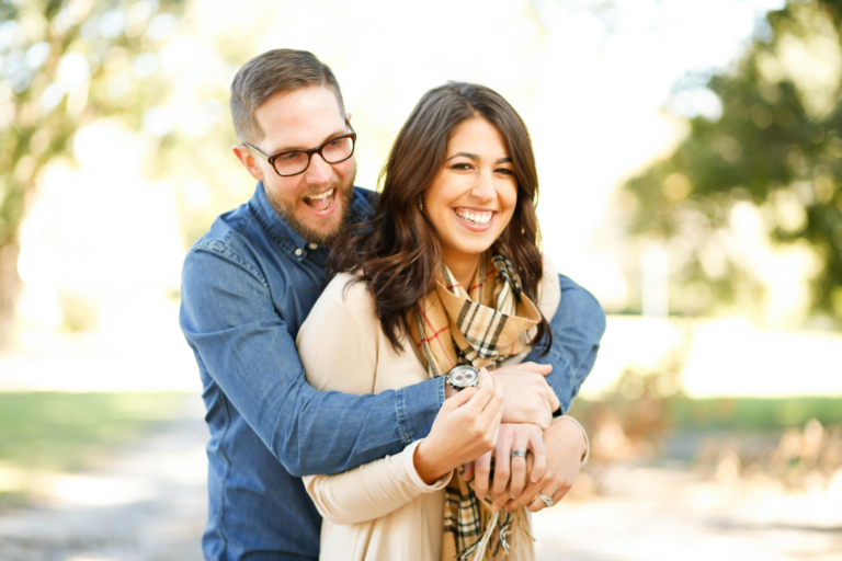 A happy looking couple holds each other, representing the ways your relationship changes after you get engaged