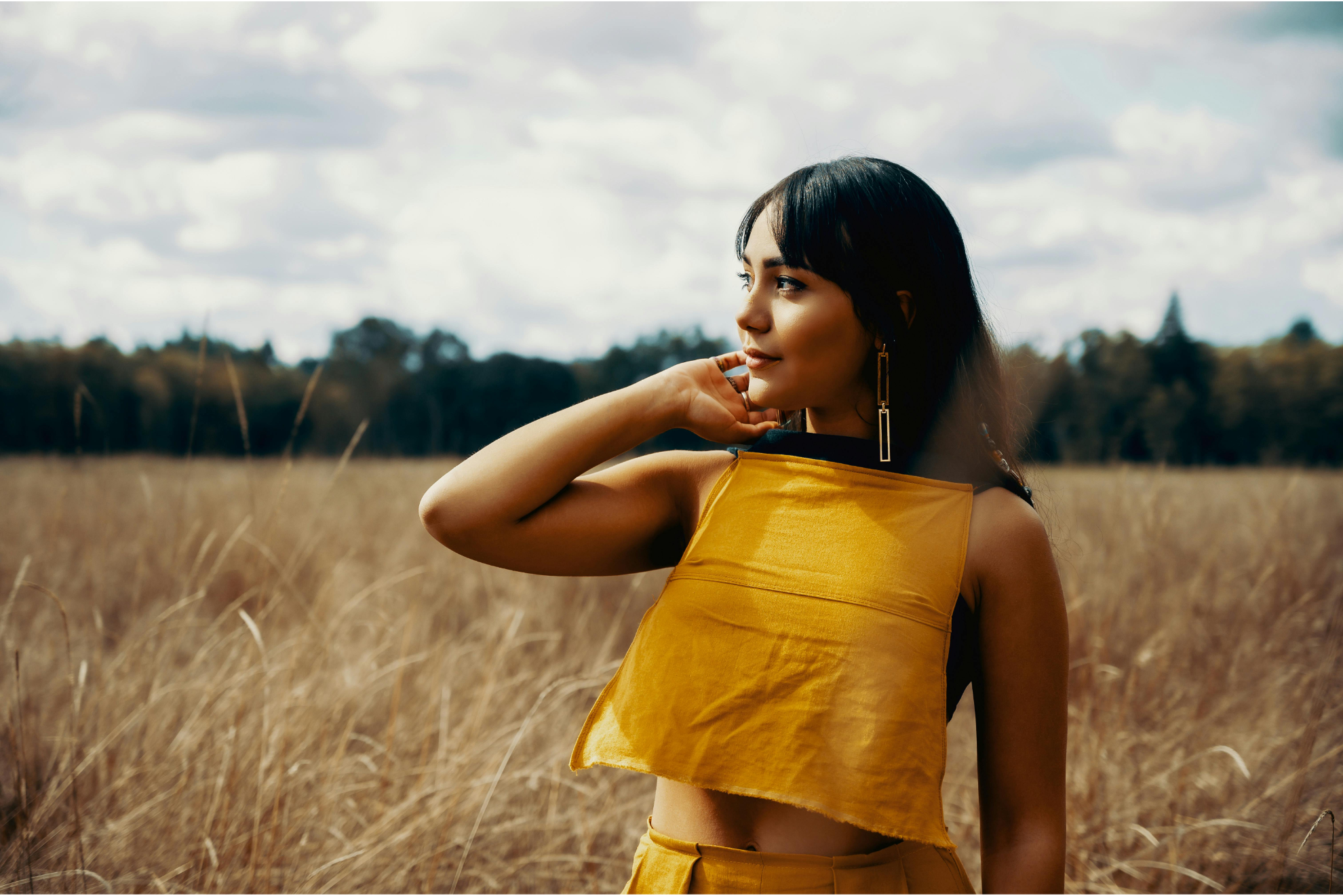 A woman stands in a field looking reflective. you are worthy of love and respect.