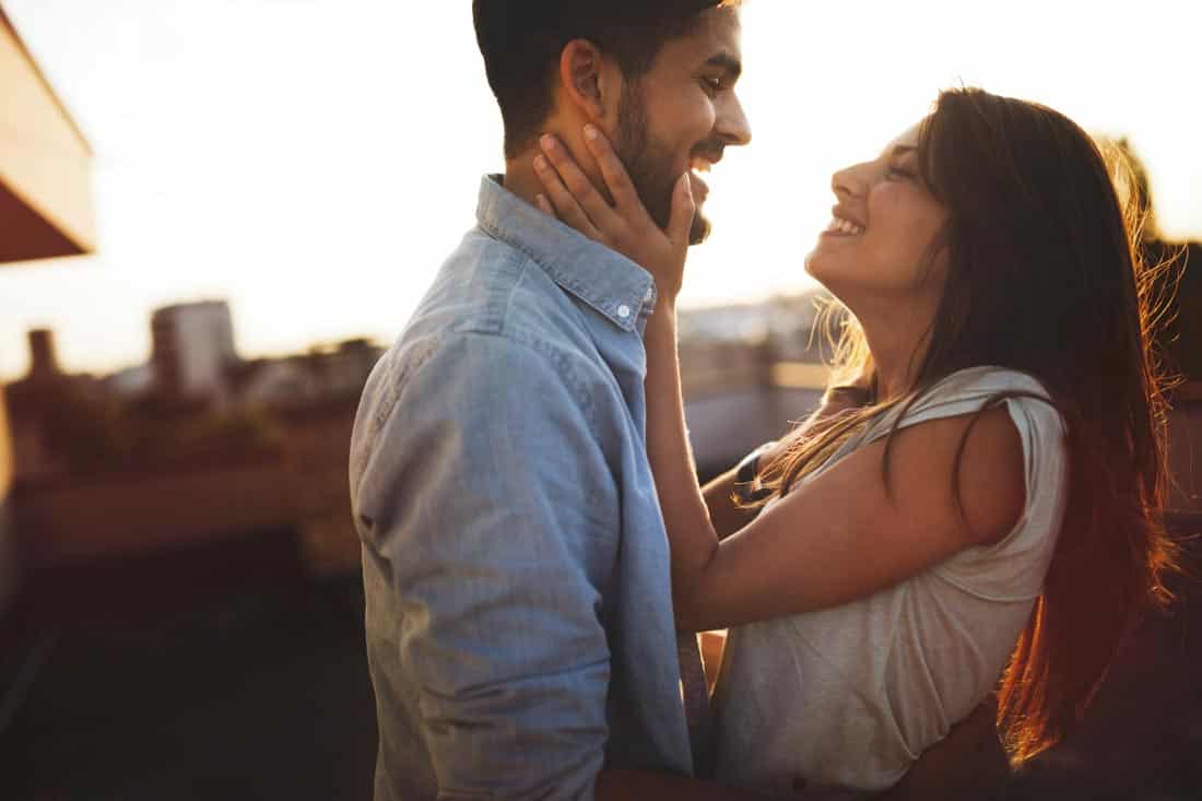Couple with woman holding man's face, representing decision to start Building a Family