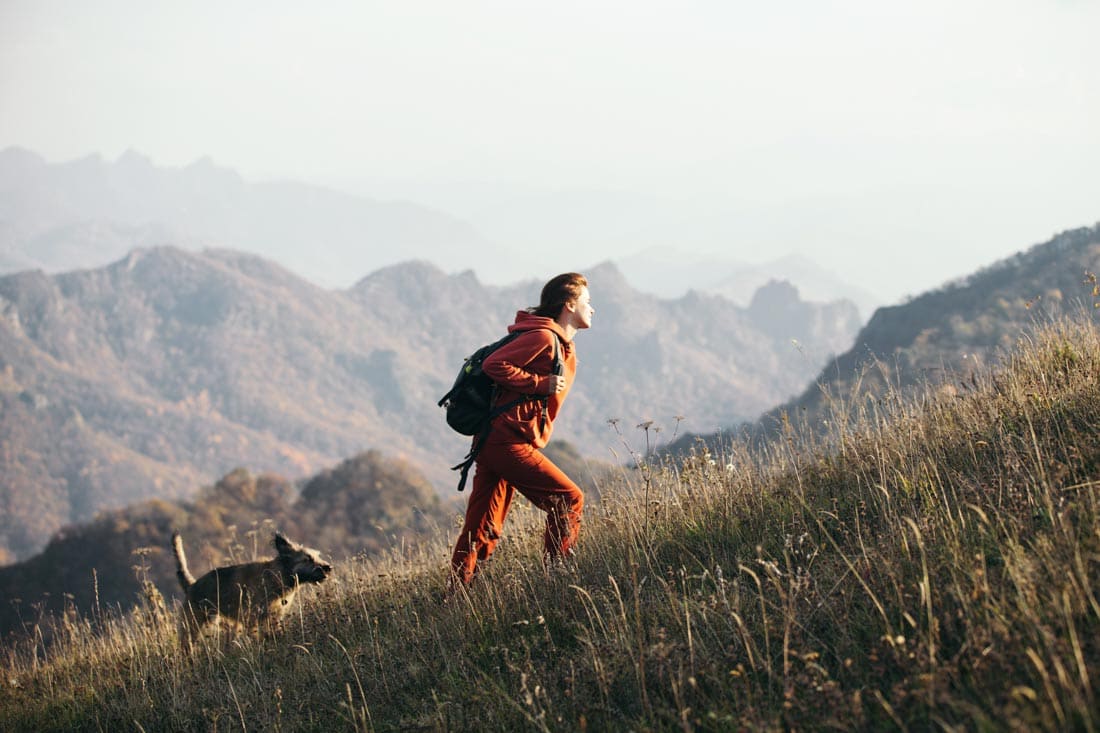 Woman hiking with dog representing therapy and coaching for growth and inner strength