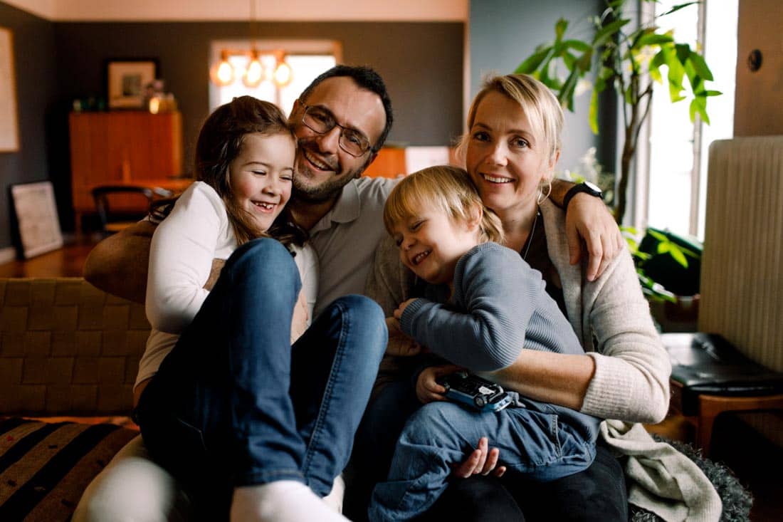 Family sitting on couch, representing happy family after blended family counseling