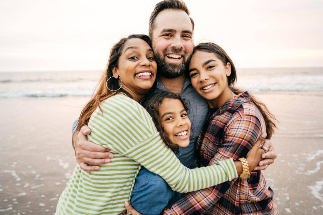 Family hugging on beach