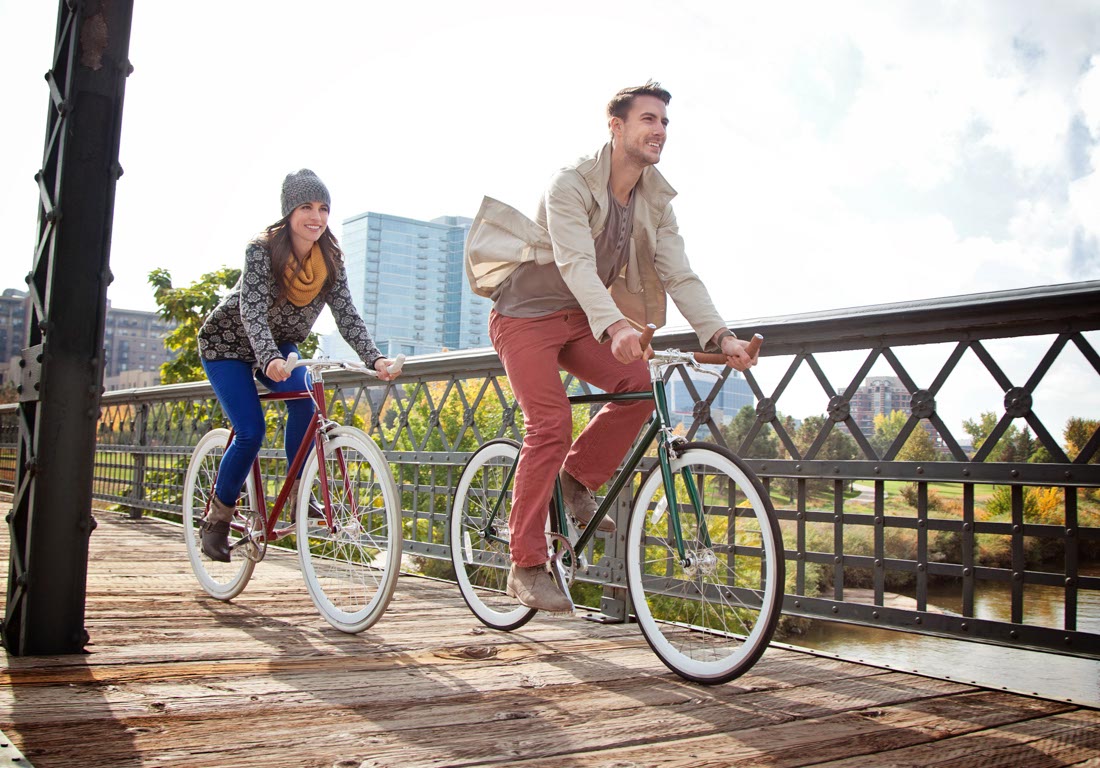 Find clarity and direction through Denver life coaching: Man and woman riding bikes across a bridge