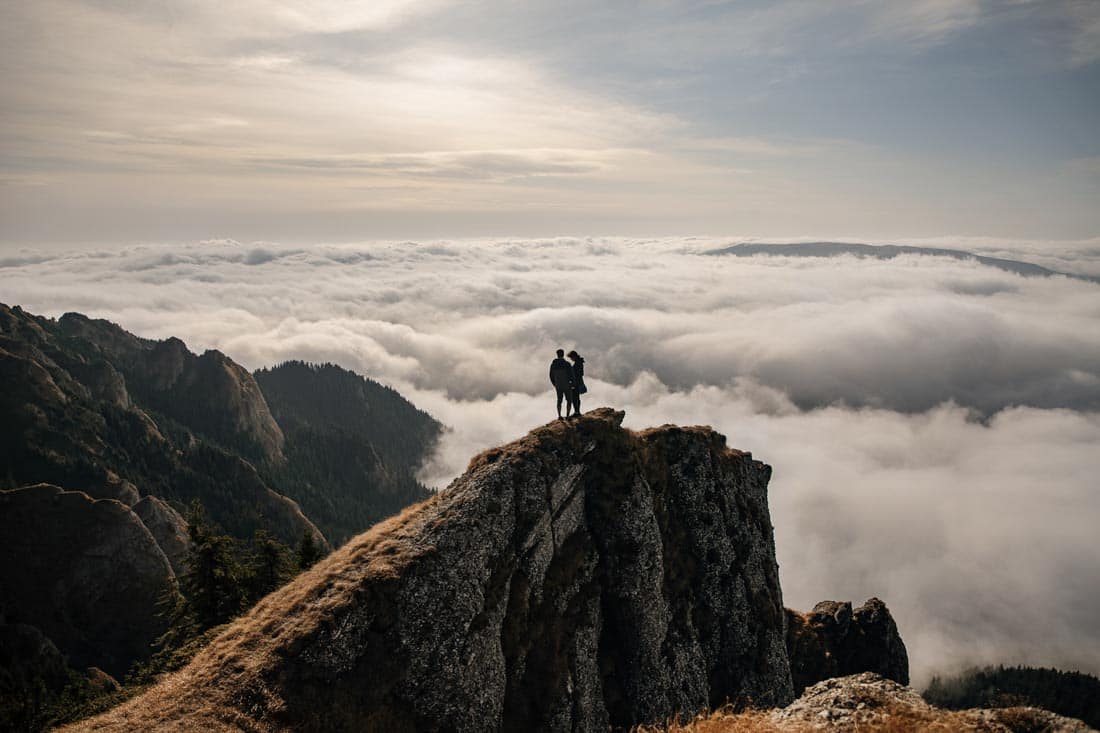 Couple on ridge above clouds