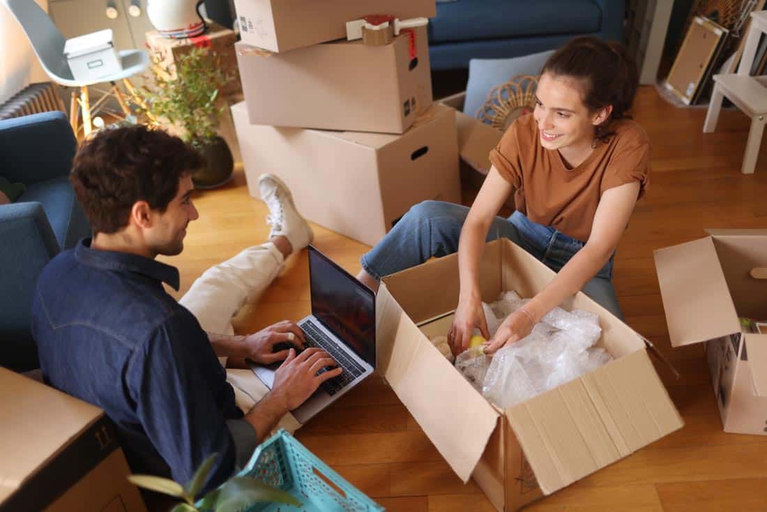 Couple unpacking moving boxes representing impact of long distance couples therapy