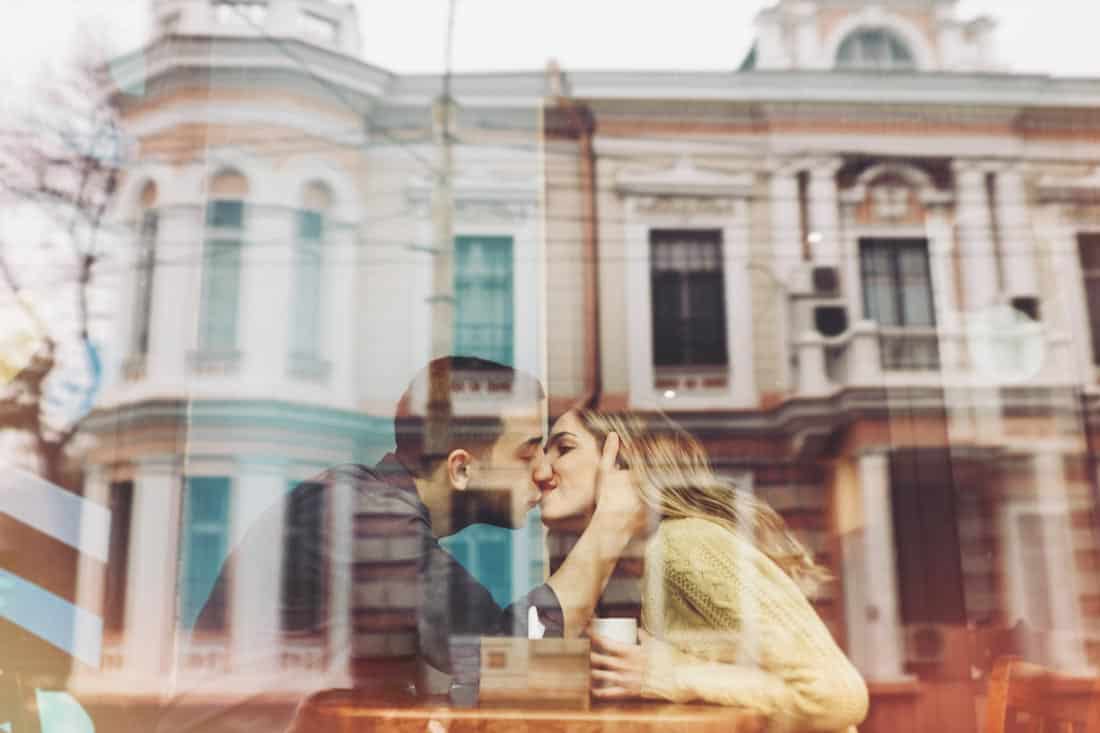 Couple kissing in window, representing long distance couples therapy