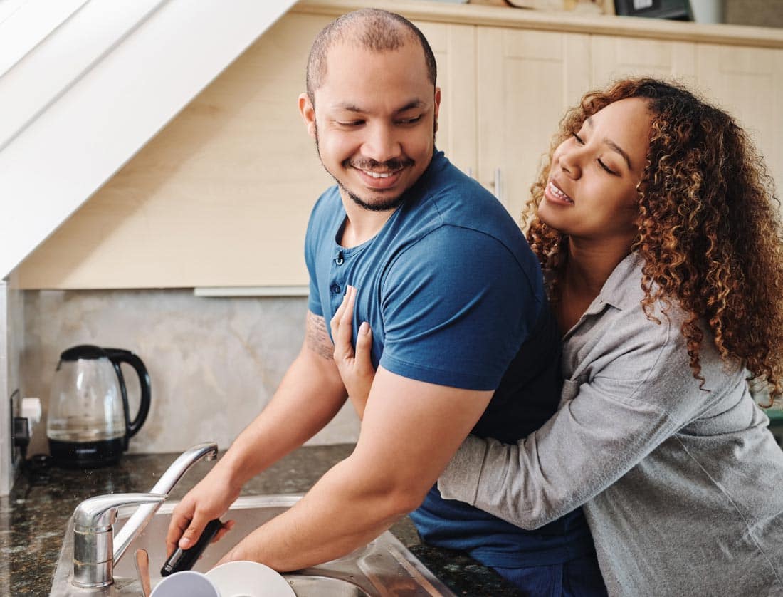 Couple washing dishes together.