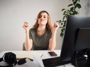 Woman procrastinating at desk.