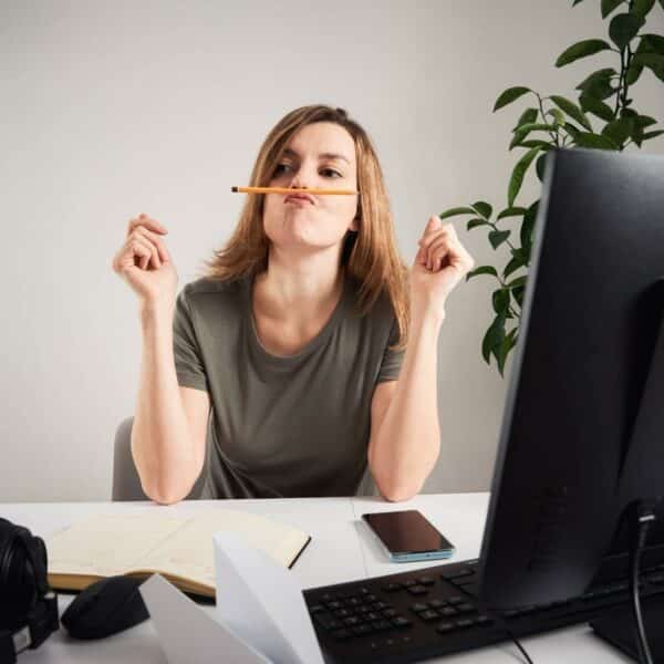 Woman procrastinating at desk.