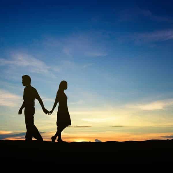 Couple walking away from each other at sunset.