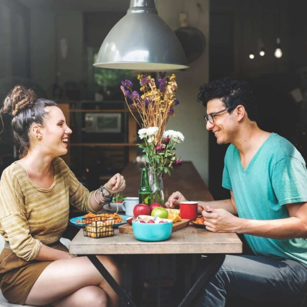 Man and woman on a date laughing and feeling confident.