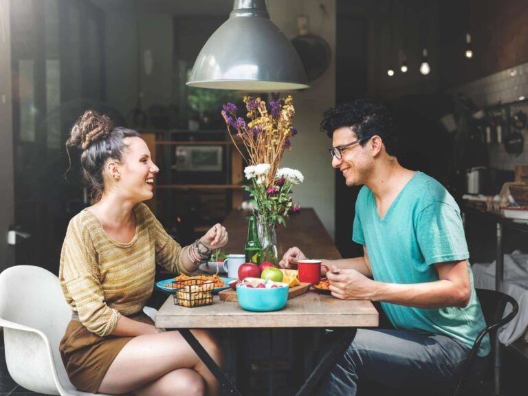 Man and woman on a date laughing and feeling confident.