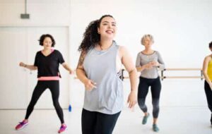 Photo of happy young woman in an exercise class, representing Advice For Mind:Body-Wellness Content Collection