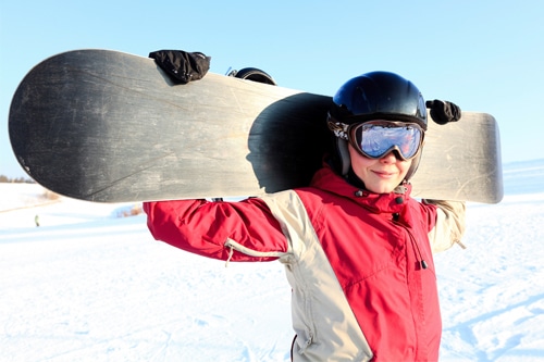 Photo of happy woman holding snowboard, representing advice for holistic life design for career and relationships