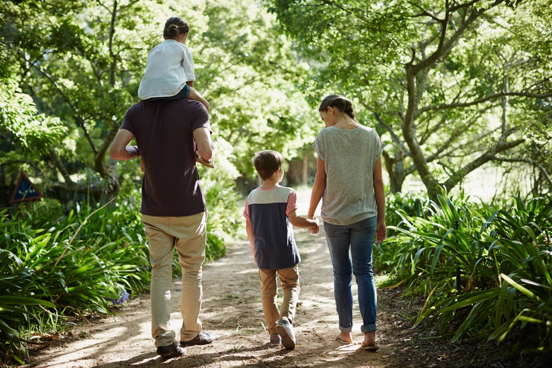 Family walking in park, representing successful affair counseling for couples