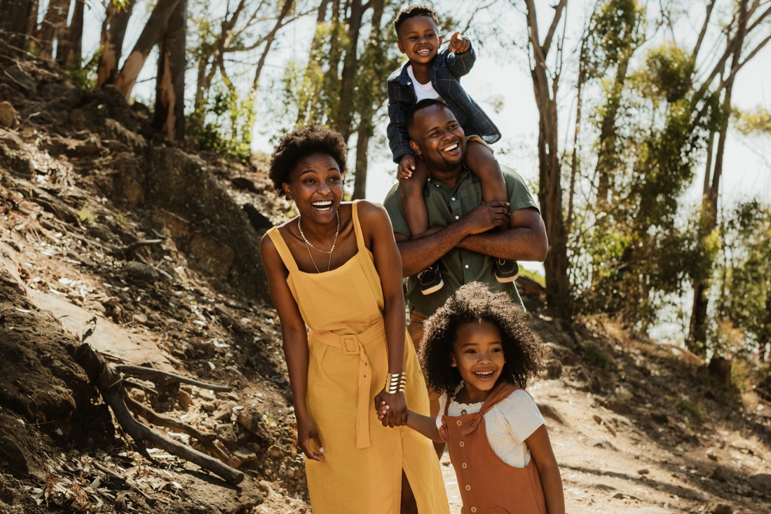 Black family hiking in park, representing Building a family together