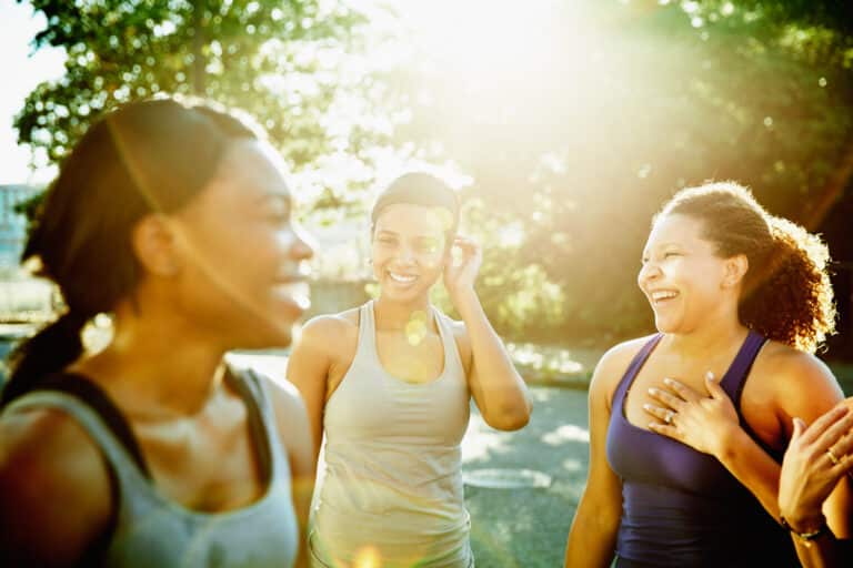 Friends laughing together after morning run in downtown neighborhood