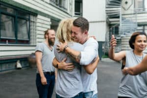 Photo of man hugging friend, representing healthy relationships.