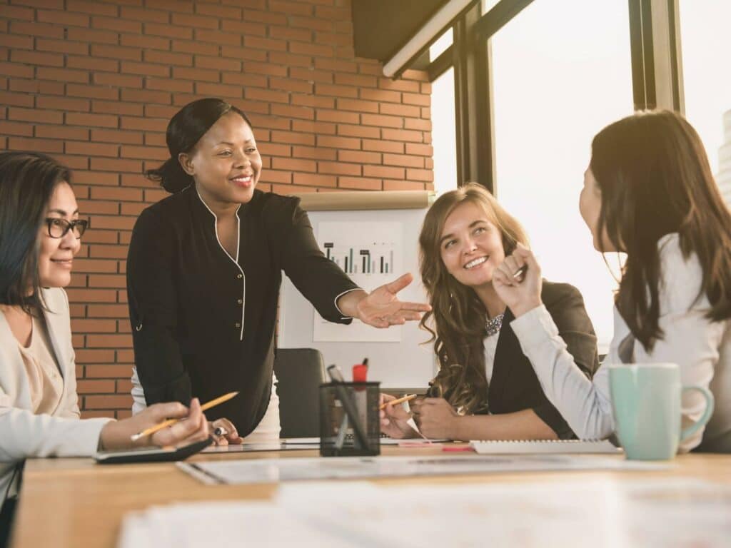 Managing up for career success, group of coworkers gathers around a table to discuss new ideas