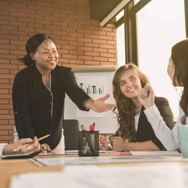 Managing up for career success, group of coworkers gathers around a table to discuss new ideas