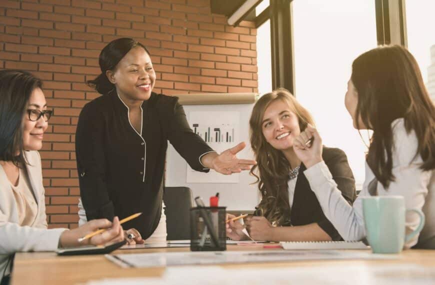 Managing up for career success, group of coworkers gathers around a table to discuss new ideas