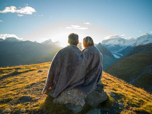 photo of couple on mountaintop with blanket around them, symbolizing relationship repair and a fresh start.