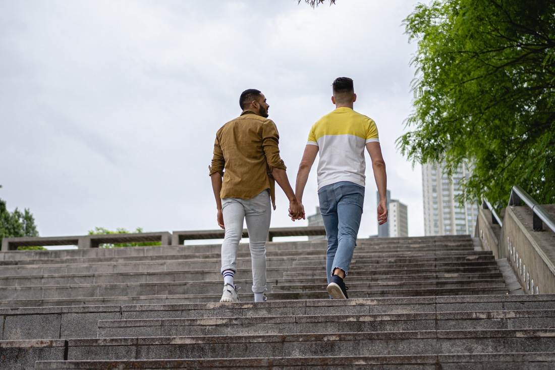 Gay couple climbing stairs together representing affair counseling