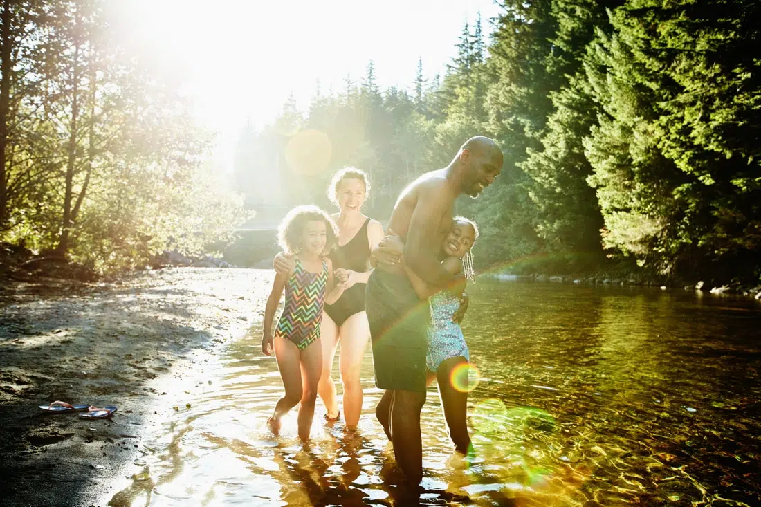 family playing together in a river