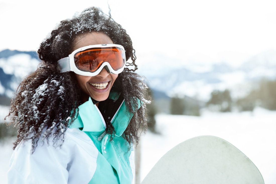 Conquer Depression: happy young woman in the snow with snowboard